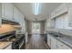 Kitchen with white cabinets, granite countertops, and black appliances at 5370 Biffle Ln, Stone Mountain, GA 30088