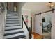 Stylish staircase with black and white design and a barn door at 125 Lamberth Lake Dr, Fayetteville, GA 30215