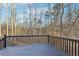 Wooden deck with black railings provides a tranquil view of the surrounding woods, perfect for relaxation at 245 London Ln, Hiram, GA 30141