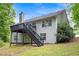 Side view of the house with a deck, staircase and green landscaping at 245 London Ln, Hiram, GA 30141