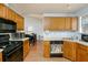 Kitchen with light wood cabinets, black appliances, and view of dining area at 3251 Hunters Crossing Pt, Lithonia, GA 30038