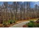 Curving driveway leading to a home nestled in a wooded area at 7760 Pleasant Hollow Ln, Cumming, GA 30041