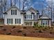 Two-story home with white siding, gray shutters, and brick accents at 7760 Pleasant Hollow Ln, Cumming, GA 30041