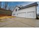 Two-car garage with white doors and large driveway at 7760 Pleasant Hollow Ln, Cumming, GA 30041