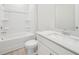 A bright bathroom featuring a tub, toilet, sink, and cabinet with white countertops and light wood flooring at 701 Lily Blossom Path Path, Lawrenceville, GA 30045