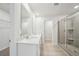 Modern bathroom with double sink vanity, framed mirrors, and glass-enclosed shower at 701 Lily Blossom Path Path, Lawrenceville, GA 30045