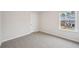 Bright bedroom featuring neutral walls, carpet, a window, and a white door at 701 Lily Blossom Path Path, Lawrenceville, GA 30045