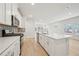 The open kitchen features a large island, modern appliances, white cabinets, gray backsplash, and hardwood flooring at 701 Lily Blossom Path Path, Lawrenceville, GA 30045