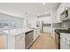 A spacious kitchen is designed with a center island, stainless steel appliances, white cabinets, and wood flooring at 701 Lily Blossom Path Path, Lawrenceville, GA 30045
