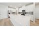 A modern kitchen features white cabinets, stainless steel appliances, and a large center island with a quartz countertop at 701 Lily Blossom Path Path, Lawrenceville, GA 30045