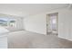 A bright and open loft offers ample space with neutral carpet, windows, and a doorway leading to another room at 701 Lily Blossom Path Path, Lawrenceville, GA 30045