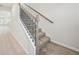 Carpeted staircase with wooden handrail and black iron balusters at 701 Lily Blossom Path Path, Lawrenceville, GA 30045