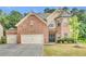 Brick two-story house with attached two-car garage and landscaped yard at 1354 Slate Bend Dr, Dacula, GA 30019