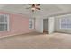 Bright main bedroom with a soft pink accent wall and ample natural light at 1354 Slate Bend Dr, Dacula, GA 30019