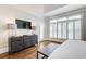 Bright bedroom featuring a dresser with lamps, a TV, and large windows with plantation shutters at 171 Johnson Ferry Nw Rd, Atlanta, GA 30328