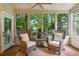 Relaxing sunroom with wicker chairs and large windows overlooking a lush garden at 765 Estate Ne Way, Atlanta, GA 30319