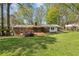 Expansive green backyard with trees, wooden deck, and patio area at 2947 Dunnington Cir, Chamblee, GA 30341