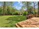 View of large, well maintained lawn and wooded perimeter, with raised wooden deck area in the foreground at 2947 Dunnington Cir, Chamblee, GA 30341