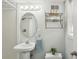 Bathroom with pedestal sink, oval mirror, and overhead vanity lighting at 2947 Dunnington Cir, Chamblee, GA 30341