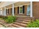 Inviting front porch features classic brick steps, brick siding, black shutters, and a white front door at 2947 Dunnington Cir, Chamblee, GA 30341