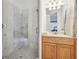 Bathroom featuring a glass-door shower, wood vanity, and modern fixtures at 3970 Bridgeman Cir, Cumming, GA 30041