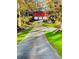 Long driveway leading to a stunning red barn-style building with three-car garage at 3970 Bridgeman Cir, Cumming, GA 30041