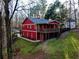 Exterior view of red barn-style building with a charming balcony and manicured lawn at 3970 Bridgeman Cir, Cumming, GA 30041