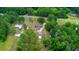 Aerial view of a property with multiple buildings, gardens, and a large, wooded area at 519 Center Point Rd, Temple, GA 30179