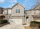 Two-story townhome with stone and siding exterior, two-car garage, and walkway at 5823 Keystone Pt, Lithonia, GA 30058