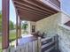 A covered back porch with a wooden deck, chairs, and access to a green backyard with a fence at 535 Crested Hawk Rdg, Canton, GA 30114