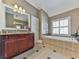 Lovely bathroom featuring a large vanity, soaking tub, and natural light from the window at 535 Crested Hawk Rdg, Canton, GA 30114