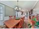 Well-lit dining room flowing into the kitchen, complete with hardwood floors and chandelier at 535 Crested Hawk Rdg, Canton, GA 30114