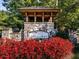 Community entrance with stone features, wood accents, and vibrant flowers at 535 Crested Hawk Rdg, Canton, GA 30114