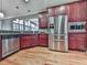 Well-equipped kitchen featuring stainless steel appliances, warm cherry wood cabinets and hardwood floors at 535 Crested Hawk Rdg, Canton, GA 30114