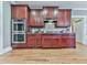 Classic kitchen showcases elegant cherry wood cabinetry, modern stainless steel appliances and beautiful wood flooring at 535 Crested Hawk Rdg, Canton, GA 30114