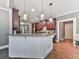 Open-concept kitchen with granite countertops, white wainscoting, stainless steel appliances, and hardwood flooring at 535 Crested Hawk Rdg, Canton, GA 30114