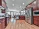 Modern kitchen with cherry wood cabinetry, stainless steel appliances, granite counters, and hardwood floors at 535 Crested Hawk Rdg, Canton, GA 30114