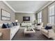 Bright living room with neutral furniture, stylish decor, and an abundance of light from the white shuttered windows at 535 Crested Hawk Rdg, Canton, GA 30114