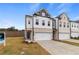 A row of new townhomes features brick facades, attached garages, and freshly installed lawns at 8194 Tiger Way, Riverdale, GA 30296