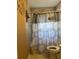 A small bathroom featuring tile walls, patterned shower curtains, and a toilet at 992 Brian Ln, Forest Park, GA 30297