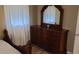 Warm, inviting bedroom with a wooden bed frame and dresser with mirror at 992 Brian Ln, Forest Park, GA 30297