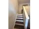 Carpeted stairs with white risers and stained treads lead to the next level of the home at 992 Brian Ln, Forest Park, GA 30297