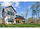 A view of the house with a manicured lawn, mature trees, and covered patio at 1820 Lake Dow Rd, Mcdonough, GA 30252