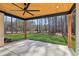 Covered patio featuring a wood ceiling, ceiling fan, and a view of the spacious, tree-lined backyard at 1820 Lake Dow Rd, Mcdonough, GA 30252