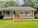 Charming home featuring a welcoming front porch with wooden posts and white railings, new steps, and fresh landscaping at 641 Virginia Ave, Suwanee, GA 30024
