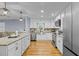 Lovely kitchen features stainless appliances, white cabinets, granite counters, pendant lighting, and hardwood floors at 641 Virginia Ave, Suwanee, GA 30024