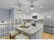 Bright kitchen features stainless appliances, white cabinets, granite counters, pendant lighting, and hardwood floors at 641 Virginia Ave, Suwanee, GA 30024
