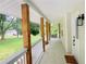 Long front porch enhanced by stained wood posts, stone tiling and white railing at 641 Virginia Ave, Suwanee, GA 30024