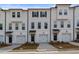 White townhomes with black accents, two-car garages, and landscaping at 3172 Washburn Sw St, Atlanta, GA 30354