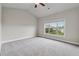 Spacious bedroom featuring plush gray carpet, a ceiling fan, and a large window with a view at 4196 Morrison Way # 11, Atlanta, GA 30341